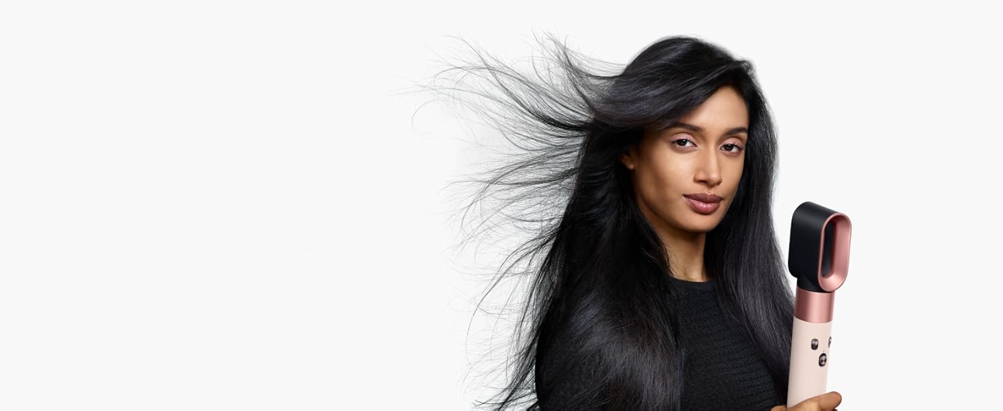 Model uses the Dyson Airwrap i.d. with the fast dryer attachment to style her hair.